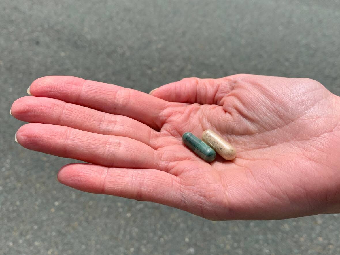 A woman holds psilocybin capsules. Psilocybin — the active ingredient in magic mushrooms — was banned in Canada in 1974.  (Melissa Tobin/CBC - image credit)