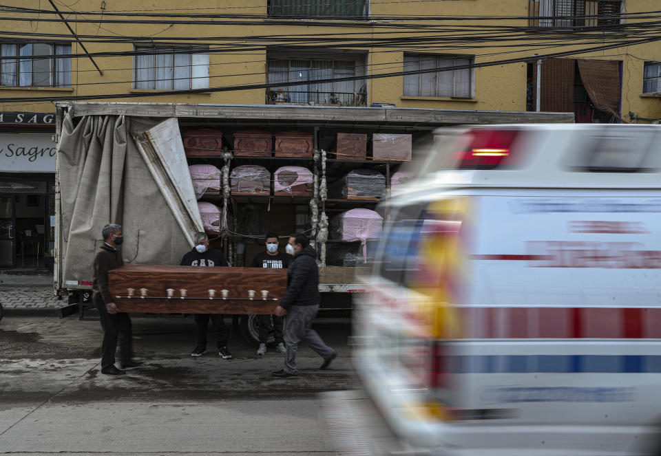 Los empleados de Bergut Servicios Fúnebres entregan ataúdes a una tienda funeraria en Santiago, Chile, el viernes 19 de junio de 2020. La producción de ataúdes ha aumentado un 120%, según el propietario Nicolás Bergerie, debido a la pandemia del nuevo coronavirus. (AP Foto/Esteban Felix)