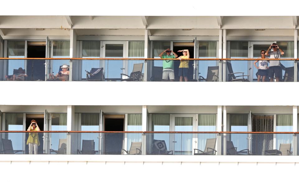 Passengers on board the MS Zaandam on their balconies as the ship arrives off the coast of Panama City: REUTERS