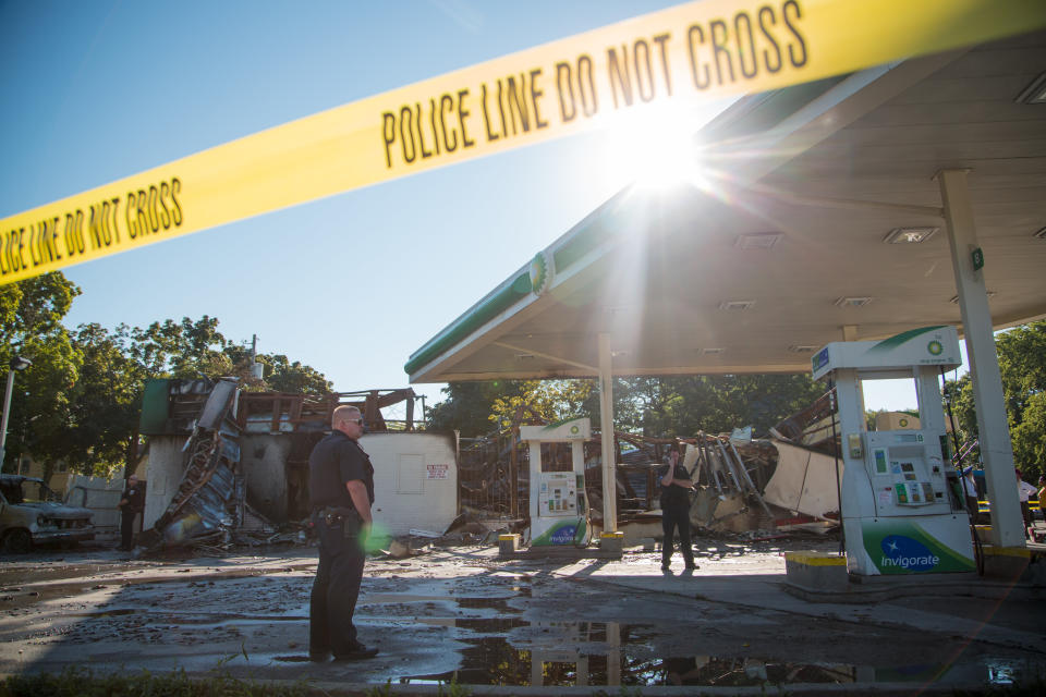 MILWAUKEE, WI - AUGUST 14: A police officer stands guard in front of the damage to the BP gas station after rioters clashed with the Milwaukee Police Department protesting an officer involved killing August 14, 2016 in Milwaukee, Wisconsin. Hundreds of angry people confronted police after an officer shot and killed a fleeing armed man earlier in the day. (Photo by Darren Hauck/Getty Images)