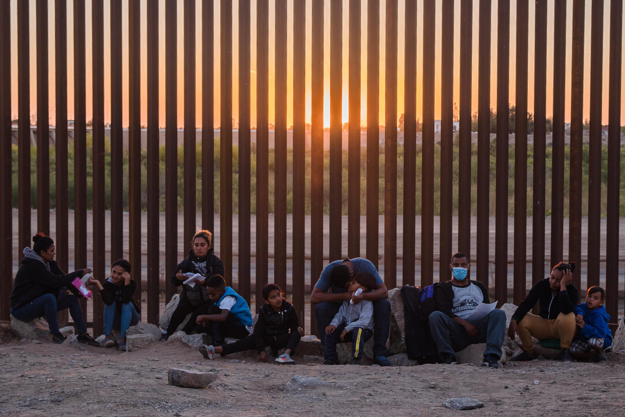 Un grupo de migrantes que cruzaron hace poco la frontera de México hacia Yuma, Arizona, esperan a que los conduzcan a un centro de procesamiento el 4 de mayo de 2021. (Ariana Drehsler/The New York Times)