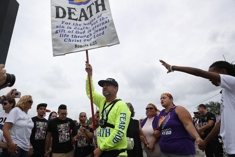 <p>Mourners circle around a man protesting against homosexuality with some chanting “Love overcomes Hate” outside the Pulse gay nightclub as a memorial service was being held for the one-year anniversary of a mass shooting at the club on June 12, 2017 in Orlando, Florida. (Joe Raedle/Getty Images) </p>