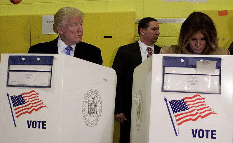 Donald Trump peers over at his wife Melania as they cast their votes at PS-59. Photo: AP