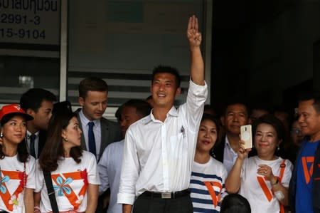 Thanathorn Juangroongruangkit, leader of the Future Forward Party flashes a three-finger salute to his supporters as he leaves a police station after hearing a sedition complaint filed by the army in Bangkok