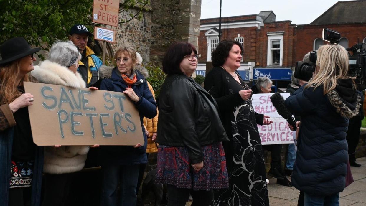 A group of protestors hold up signs reading "Save St Peters"