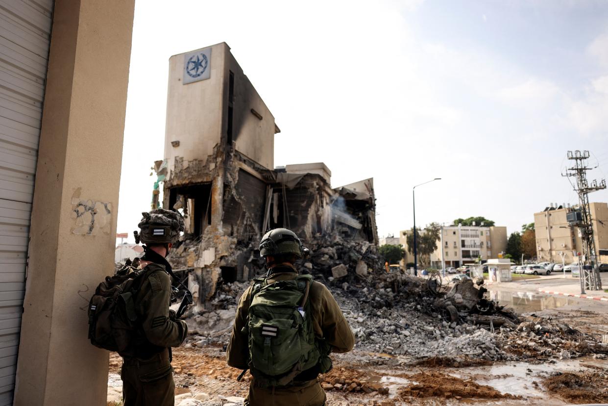 Israeli soldiers look at the remains of a police station in Sderot, which was the site of a battle following a mass infiltration by Hamas gunmen from the Gaza Strip on Saturday (REUTERS/Ronen Zvulun)