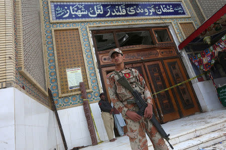 A paramilitary soldier guards the entrance door, which is cordoned with a yellow tape, at the tomb of Sufi saint Syed Usman Marwandi, also known as the Lal Shahbaz Qalandar shrine, after Thursday's suicide blast in Sehwan Sharif, Pakistan's southern Sindh province, February 17, 2017. REUTERS/Akhtar Soomro