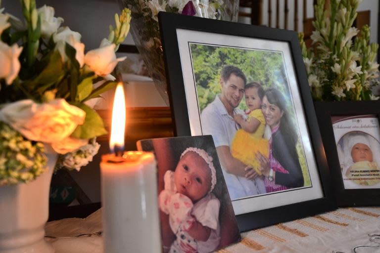 Family pictures show Arnold Huizen (L), his wife Yodricunda Theistiasih Titihalawa (R) and their daughter Yelena Clarice Huizen (C), Indonesian victims of the MH17 crash, in Jimbaran, Bali, on July 20, 2014