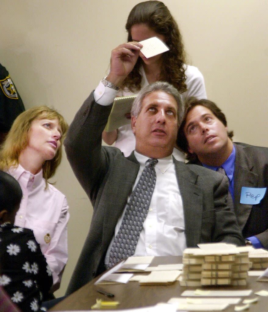 Palm Beach County, Florida Supervisor of Elections Theresa LePore (L), Palm Beach County Voting Canvassing Board Chairman Judge Charles Burton (C) and an unidentified Republican observer (R) inspect a questionable ballot, Nov. 11, 2000, in the Palm Beach County elections office in Florida.<span class="copyright">Bruce Weaver—AFP via Getty Images</span>