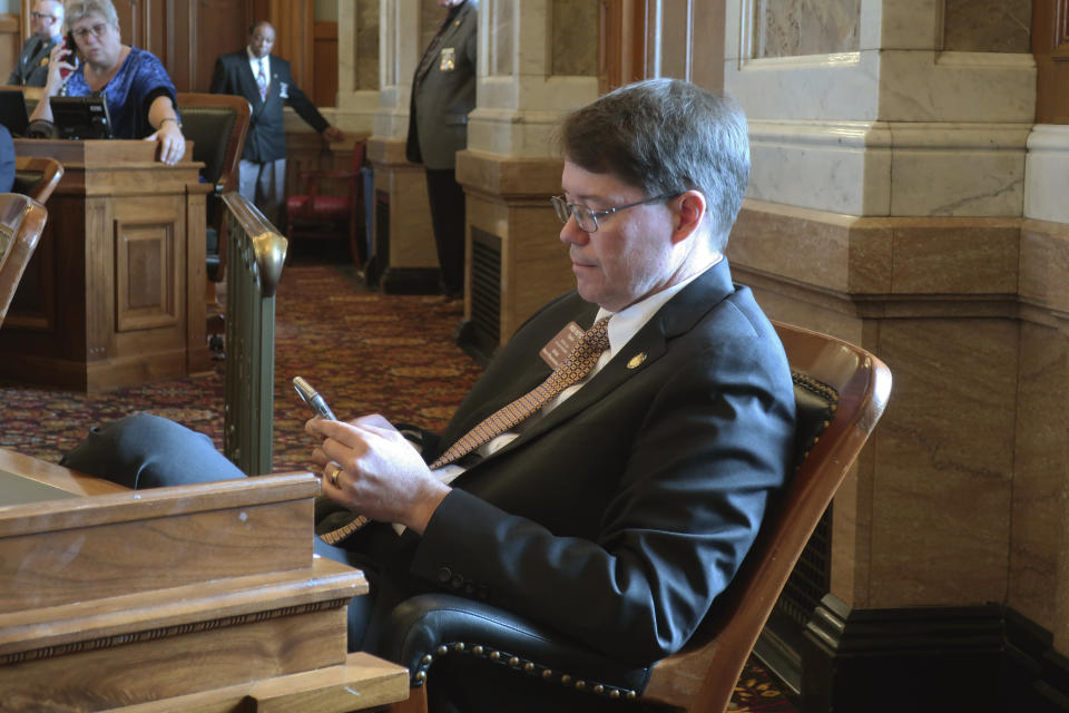 Kansas state Rep. Fred Patton, R-Topeka, works with the House roll still open on a vote on a proposed amendment to the state constitution on abortion, Friday, Feb. 7, 2020, at the Statehouse in Topeka, Kan. Patton is supporting the measure, which would overturn a Kansas Supreme Court decision that declared access to abortion a "fundamental" right under the state's Bill of Rights. (AP Photo/John Hanna)