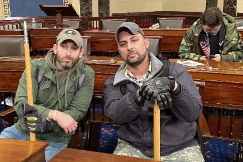 Joseph Irwin and John Richter inside the Capitol  at Senate desks on Jan. 6, 2021. (U.S. District Court for the District of Columbia)