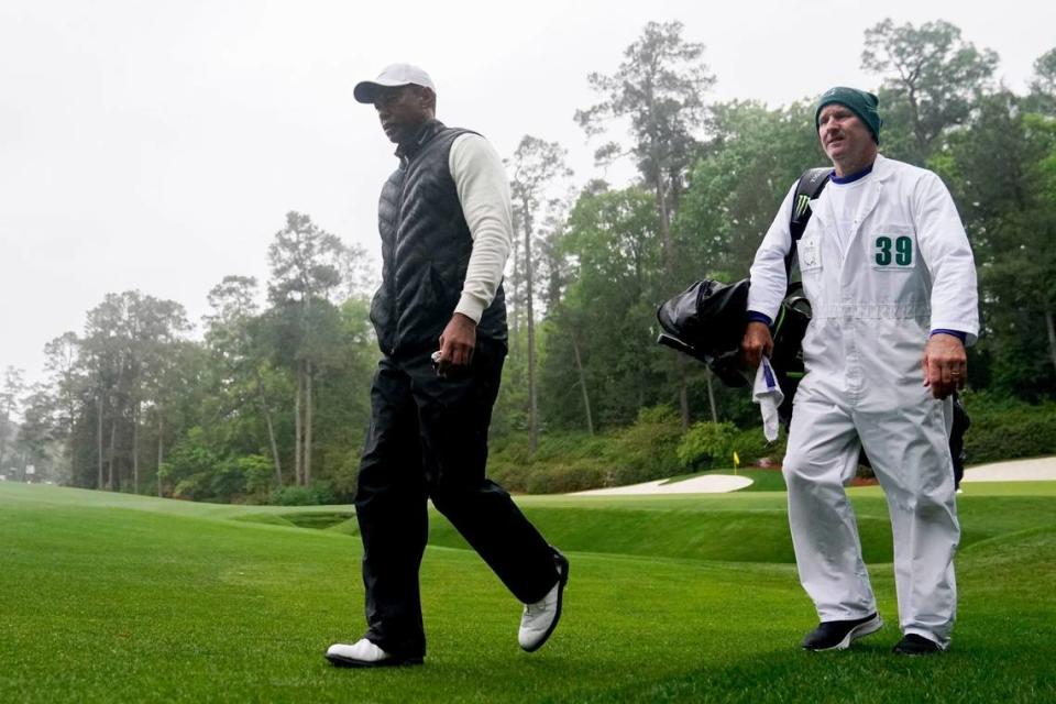 Tiger Woods walks to the 14th tee with caddie Joe LaCava during the second round of The Masters golf tournament in 2023. Danielle Parhizkaran/USA TODAY