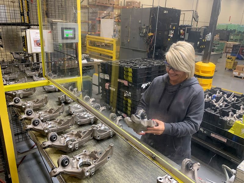 A production worker inspects parts for any quality issues at auto supplier Aludyne in Port Huron
