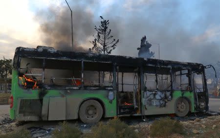 A bus is set on fire while en route to evacuate ill and injured people from the besieged Syrian villages of al-Foua and Kefraya, after they were attacked and burned, in Idlib province, Syria December 18, 2016. REUTERS/Ammar Abdullah