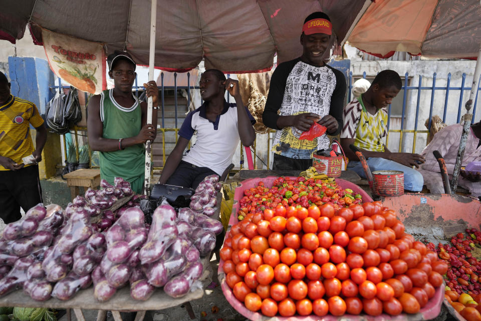 People sells tomatoes and onions at a market in Lagos, Nigeria Monday, Feb. 27, 2023. Each of the three frontrunners in Nigeria's hotly contested presidential election claimed they were on the path to victory Monday, as preliminary results trickled in two days after Africa's most populous nation went to the polls. (AP Photo/Sunday Alamba)