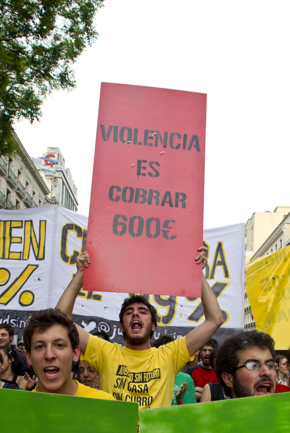 Demonstrators march towards Puerta del Sol plaza in central Madrid, Saturday May 12, 2012. Demonstrators arrived in Sol from four different directions as protesters returned to Sol to mark the anniversary of the protest movement that inspired groups in other countries. The protests began May 15 last year and drew hundreds and thousands of people calling themselves the indignant movement. The demonstrations spread across Spain and Europe as anti-austerity sentiment grew. Banner reads '"Violence is earning 600 euros a month". (AP Photo/Paul White)