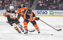 Anaheim Ducks' Benoit-Olivier Groulx (50) chases Edmonton Oilers' Tyson Barrie (22) during the first period of an NHL hockey game Tuesday, Oct. 19, 2021, in Edmonton, Alberta. (Jason Franson/The Canadian Press via AP)