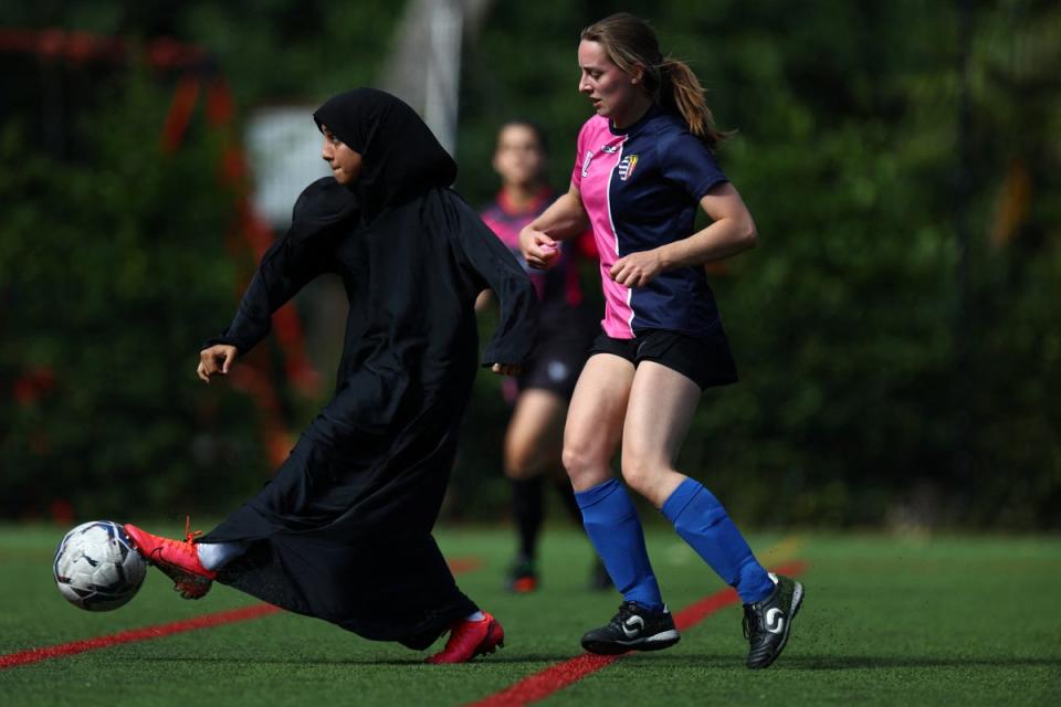 Sisterhood player Raya Ahmed kicks the ball during a tournament match against PCWAFC at Archbishop's Park football pitch (Reuters)