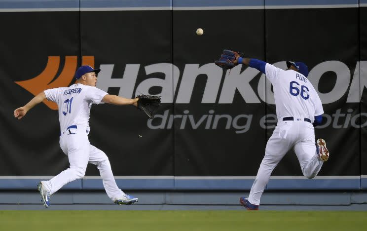 Los Angeles Dodgers right fielder Yasiel Puig, right, makes a catch on a ball hit by St. Louis Cardinals' Yadier Molina before colliding with center fielder Joc Pederson during the 10th inning of a baseball game, Tuesday, May 23, 2017, in Los Angeles. (AP Photo/Mark J. Terrill)