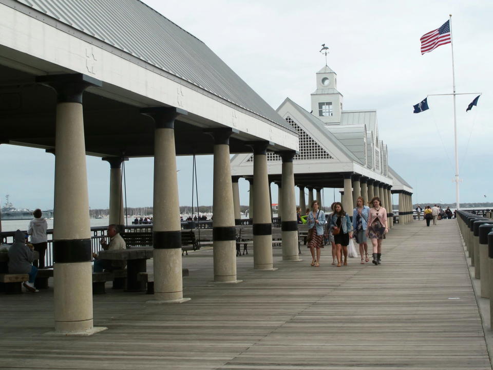 Visitors walk along the pier at the Waterfront Park in Charleston, S.C. on March 11, 2013. The pier reaching into the Cooper River provides a great view of ships and boats passing by and has swings where visitors can catch a cool breeze on hot days and pass some time near the water. (AP Photo/Bruce Smith)