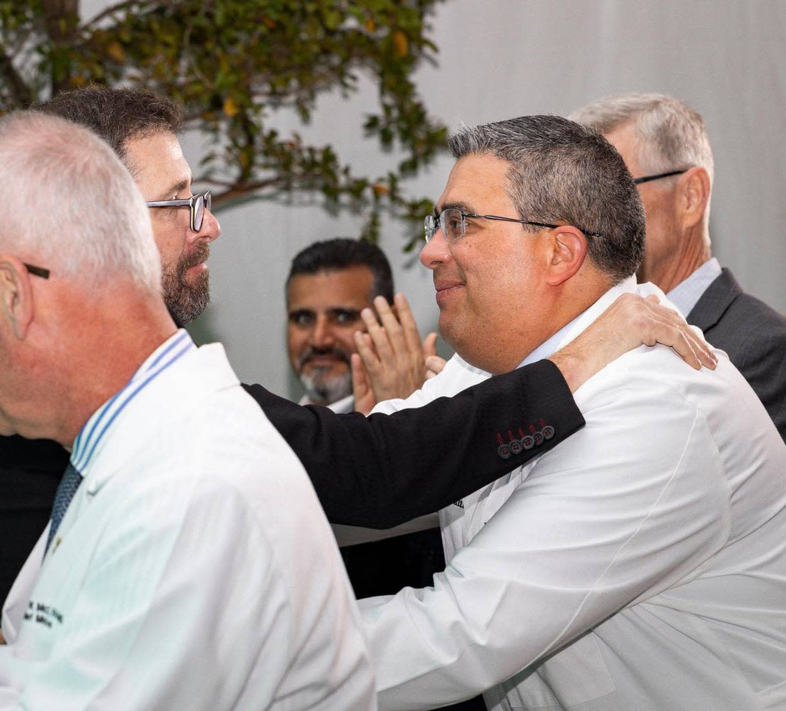 Sebastian Krys, 22-time Grammy and Latin Grammy award-winner and Parkinson’s patient, left, embraces his doctor, Diego Torres-Russotto, during a ceremony recognizing Ken Griffin, Citadel CEO, for his donation to the Miami Neuroscience Institute on Tuesday, March 19, 2024, at the Baptist Health Baptist Hospital in Miami, Fla. Alie Skowronski/askowronski@miamiherald.com