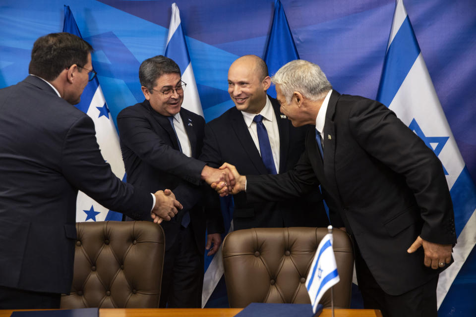 Israeli Prime Minister Naftali Bennett, second right, shakes hands with Honduran Foreign Minister Lisandro Rosales as Honduran President Juan Orlando Hernandez, second left, shakes hands with Israeli Foreign Minister Yair Lapid, after signing agreements between their two countries, at the prime minister's office, in Jerusalem, Thursday, June 24, 2021. (Heidi Levine/Pool via AP).