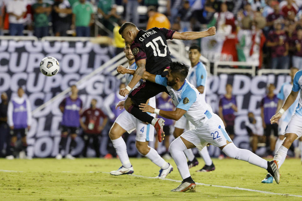 Mexico midfielder Orbelin Pineda (10) scores as he is defended by Guatemala defender Jose Morales (22) during the second half of a CONCACAF Gold Cup Group A soccer match in Dallas, Wednesday, July 14, 2021. (AP Photo/Michael Ainsworth)