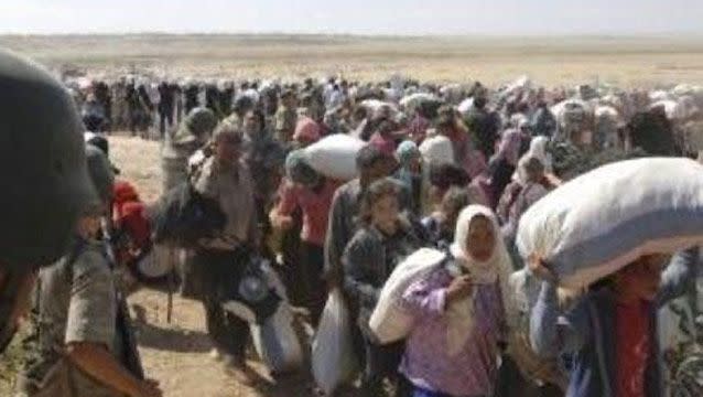 Syrian Kurds cross the border fence into Turkey. Source: Reuters