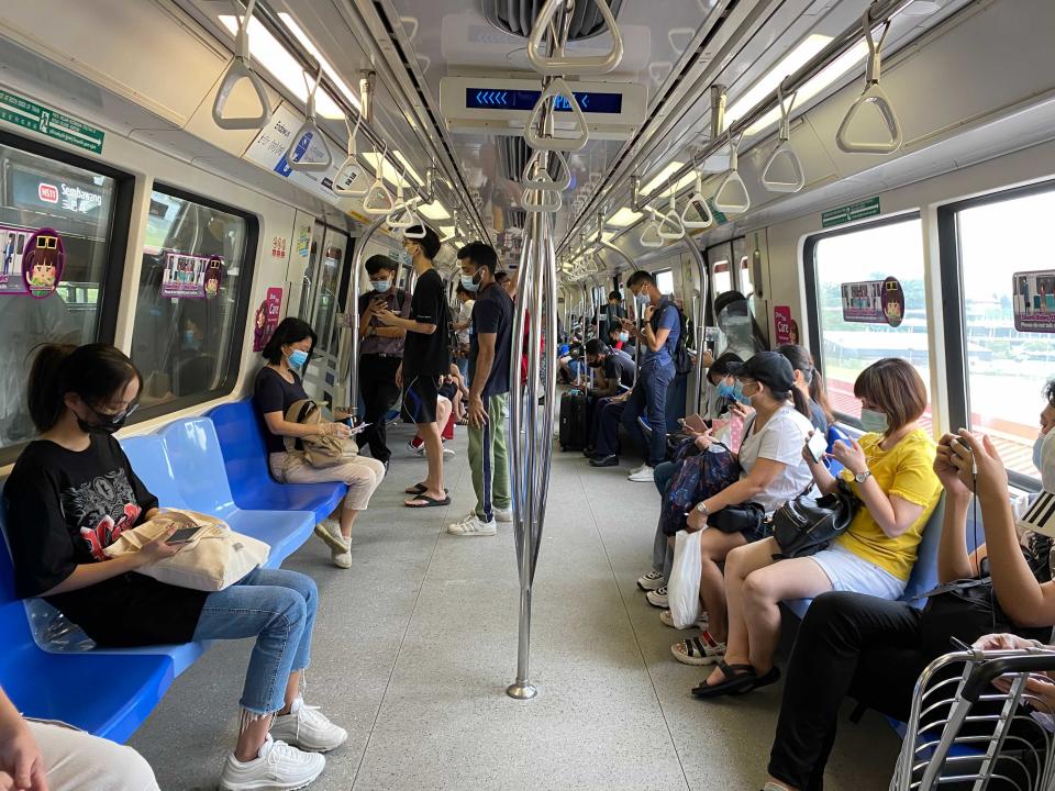 Commuters wear face masks and practice social distancing while onboard a subway Wednesday, May 19, 2021 in Singapore. Across much of Asia, taxi drivers are starved for customers, weddings are suddenly canceled, schools are closed, and restaurant service is restricted as the coronavirus comes surging back in countries where it had seemed to be well under control. (AP Photo/Zen Soo)