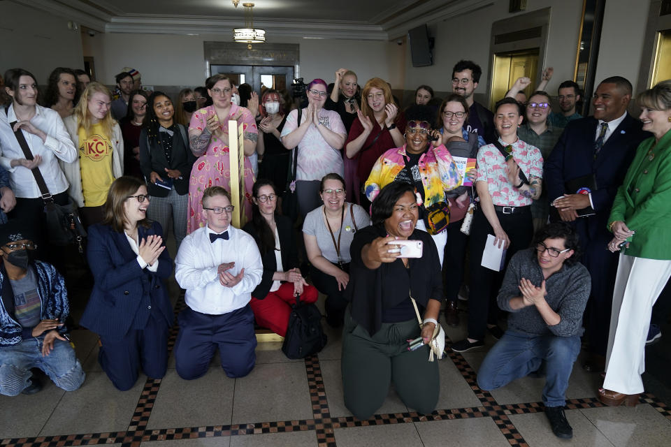 Supporters of a resolution that would make Kansas City, Mo, a sanctuary city for transgender people celebrate outside of city council chambers after a committee approved the resolution, sending it to the full council for consideration, Wednesday, May 10, 2023, in Kansas City, Mo. The move comes in the wake of Missouri legislators voting to ban gender-affirming care and trans athletes. (AP Photo/Charlie Riedel)