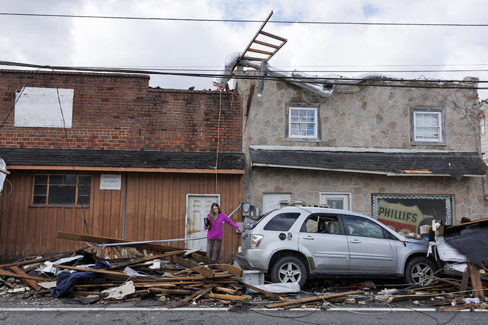 A woman exits a tornado damaged building on April 3, 2024 in Sunbright, Tenn. (Brett Carlsen / Getty Images)