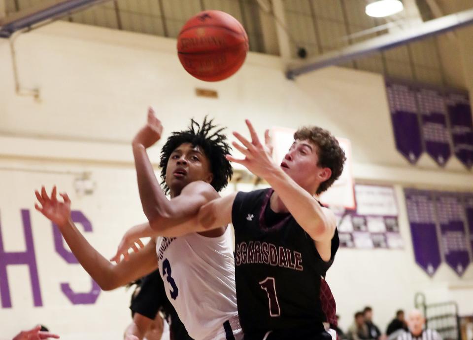 From left, New Rochelle's Malik Gasper (3) and Scarsdale's Jake Sussberg (1) battle for a rebound during boys basketball action at New Rochelle High School Jan. 3, 2024. New Rochelle won the game 63-49.