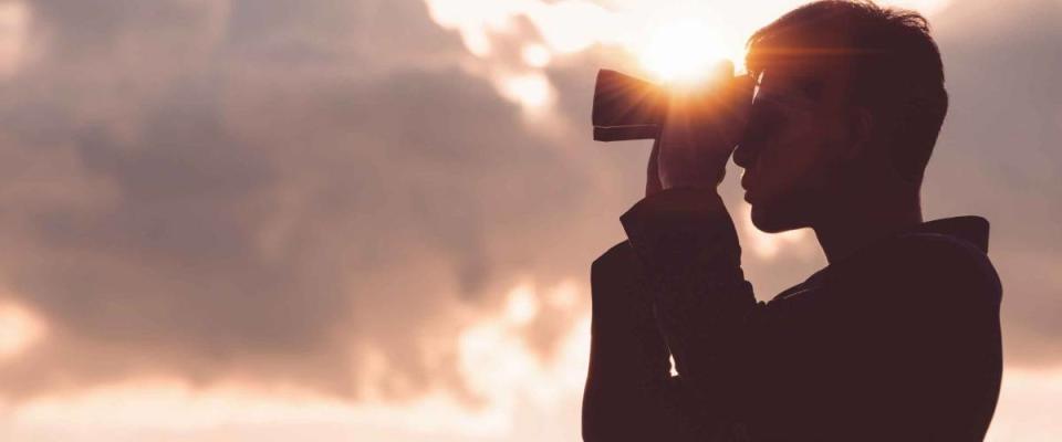 Asian man Hand Holding Binoculars / looking / watching using Binoculars with copyspace,Concept of The pursuit of profitable business in the future.