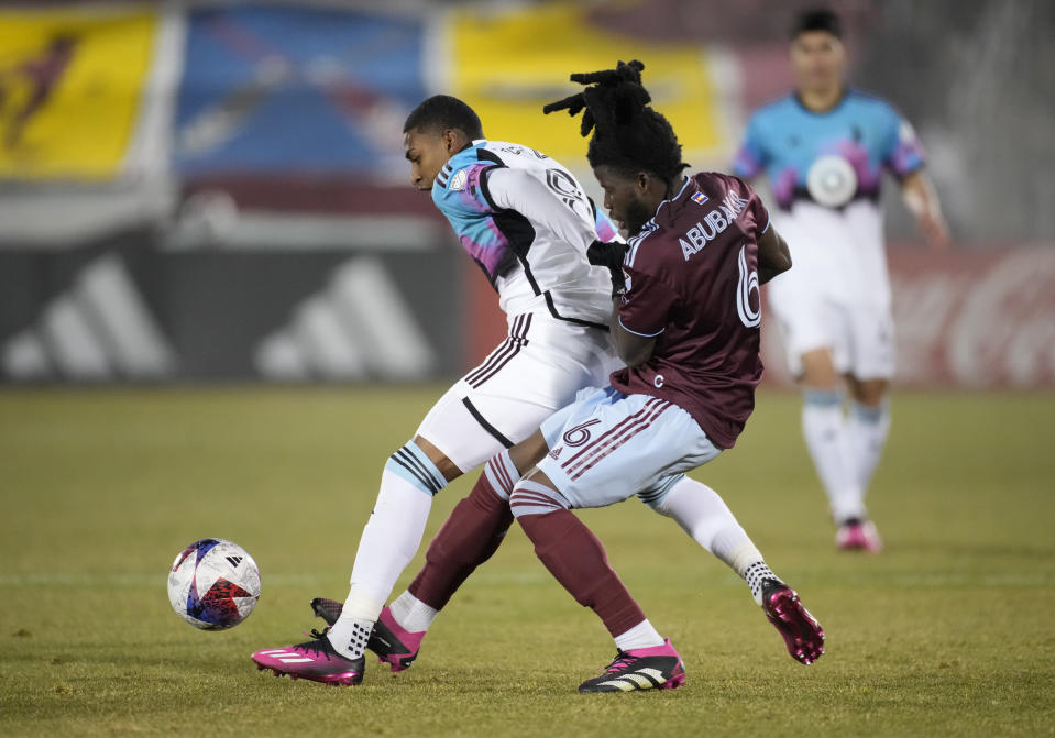 Colorado Rapids defender Lalas Abubakar, right, tries to get to the ball from behind Minnesota United midfielder Joseph Rosales during the second half of an MLS soccer match Saturday, March 18, 2023, in Commerce City, Colo. (AP Photo/David Zalubowski)