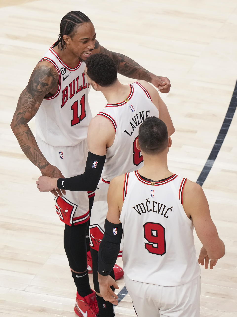 Chicago Bulls forward DeMar DeRozan (11) celebrates with Zach LaVine (8) and Nikola Vucevic (9) after the team's win over the Toronto Raptors in an NBA basketball play-in tournament game Wednesday, April 12, 2023, in Toronto. (Nathan Denette/The Canadian Press via AP)
