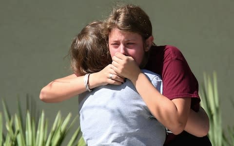 Students grieve after Wednesday's mass shooting at Marjory Stoneman Douglas High School  - Credit:  Joel Auerbach