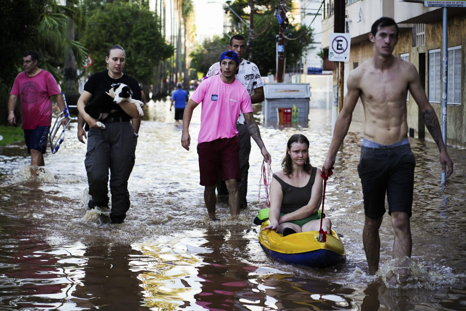 A woman is rescued from an area flooded by heavy rains in Porto Alegre, Rio Grande do Sul state, Brazil, Monday, May 6, 2024. (AP Photo/Carlos Macedo)