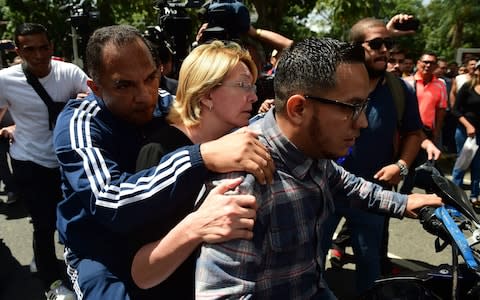 Ms Ortega is seen on a motorbike during a flash visit to the Public Prosecutor's office in Caracas on August 5 - Credit: RONALDO SCHEMIDT/AFP/Getty Images