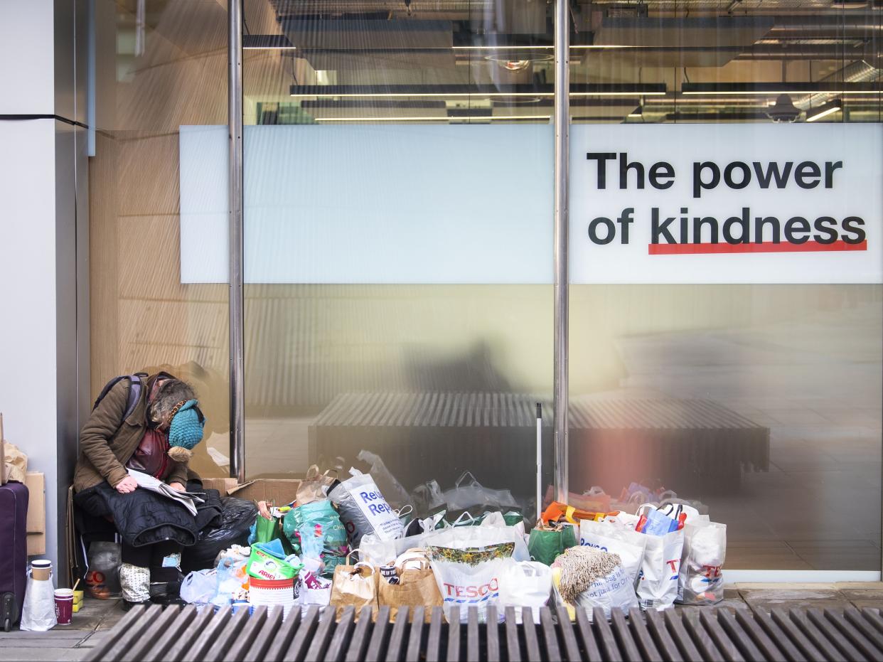 A homeless person sits in a window in the City of London during England's third national lockdown to curb the spread of coronavirus (PA)