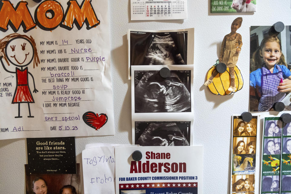 Ultrasound images of Alisha Alderson hang on the refrigerator of the family's kitchen in Baker City, Ore., on Thursday, Aug. 31, 2023. “We don’t feel safe being so far away from a birthing center,” said Alderson, noting her advanced maternal age of 45. (AP Photo/Kyle Green)