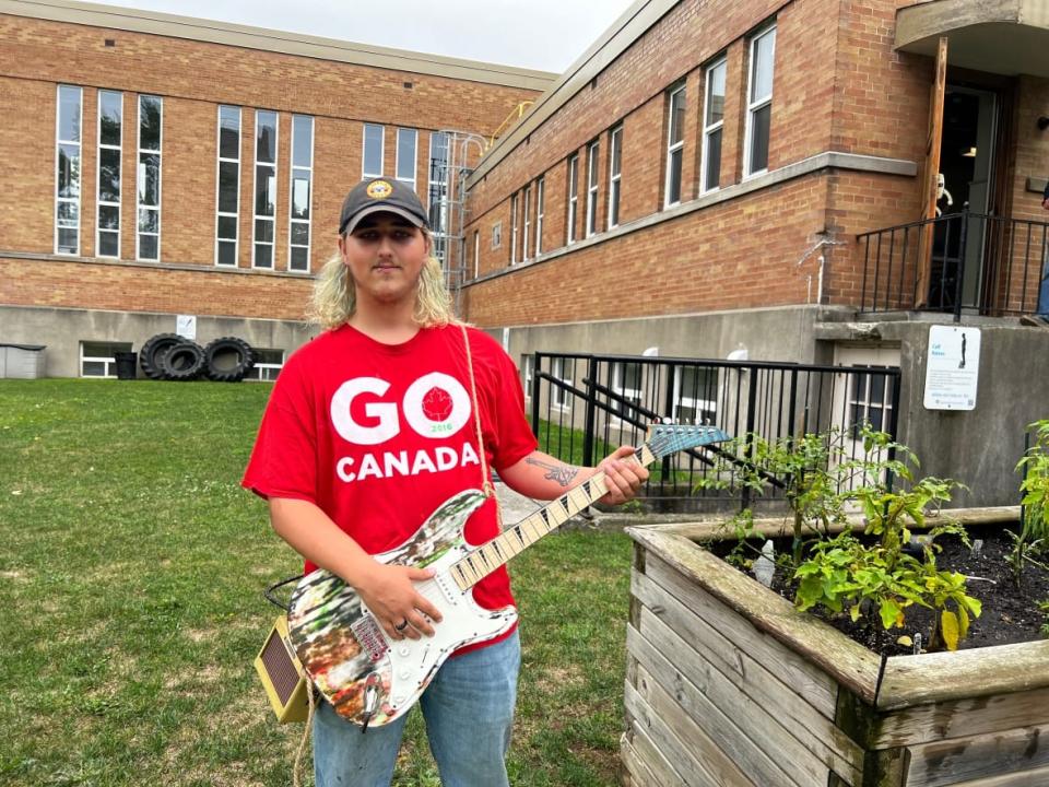 Devin Millette, 19, loves spending time at the garden outside the London Health Sciences Centre in Ontario where he plants and plays tunes for his fellow psychiatry patients.   (Isha Bhargava/CBC - image credit)