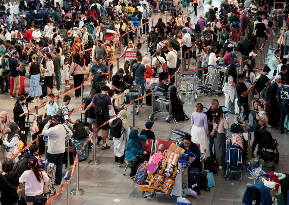 AirAsia passengers wait to be checked in manually at Kuala Lumpur International Airport's Terminal 2, after a global IT system outage, in Sepang, Malaysia, July 19, 2024.