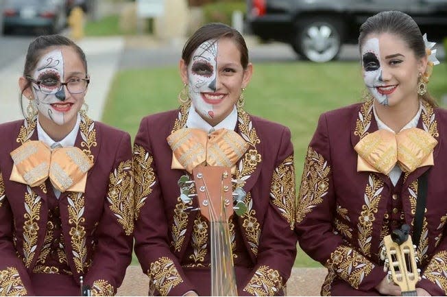 A group of mariachi performers with sugar skull face paint designs at one Día de Los Muertos celebration in the High Desert.