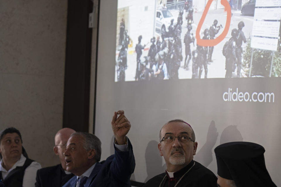 The Latin Patriarch of Jerusalem Pierbattista Pizzaballa looks up at a video of Israeli police in riot gear during the funeral of slain Al Jazeera correspondent Shireen Abu Akleh on Friday, during a press conference about police violence against pallbearers at the funeral, in east Jerusalem, Monday, May 16, 2022. Pizzaballa, the top Catholic clergyman in the Holy Land, said Israel's police attack on mourners during a funeral for Abu Akleh was a violation of human rights and disrespected the Catholic Church. (AP Photo/ Maya Alleruzzo)