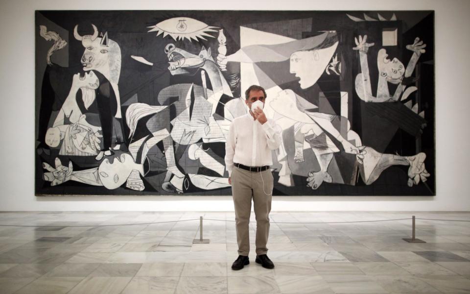 The director of the Reina Sofia Museum, Manuel Borja-Villel, poses next to Pablo Picasso's painting 'Guernica' - Getty