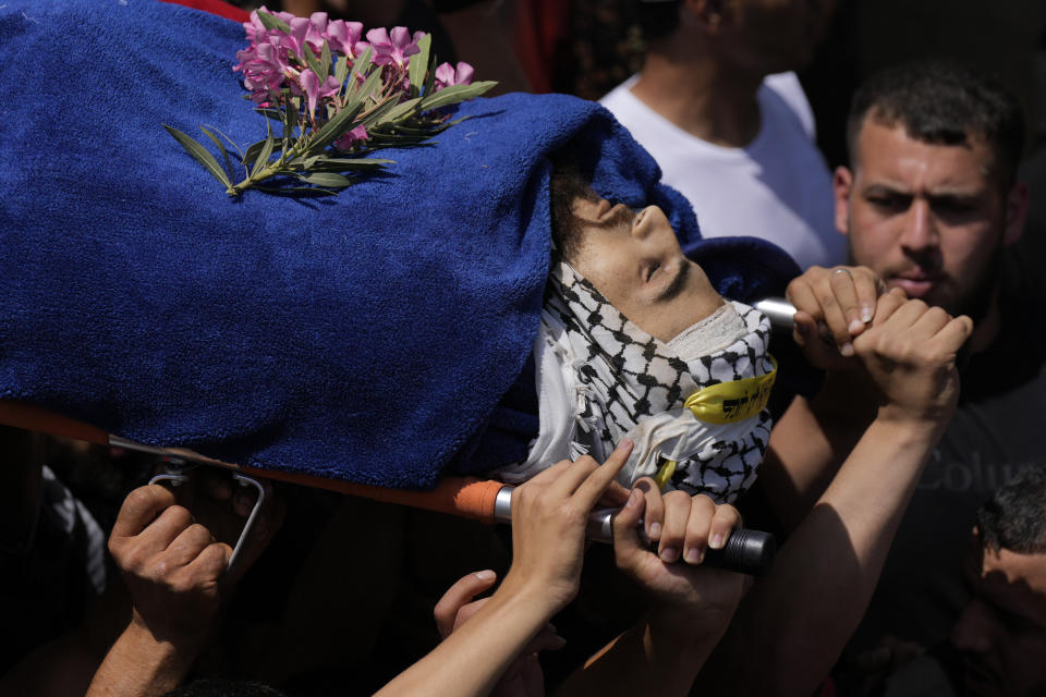 Palestinian mourners carry the body of Bilal Kabaha during his funeral in the West Bank village of Yabed, Thursday, June 2, 2022. Kabaha was killed during clashes with Israeli forces when they entered Yabed to demolish the family home of a slain Palestinian attacker who had gunned down five people in the Israeli city of Bnei Brak in March. (AP Photo/Majdi Mohammed)