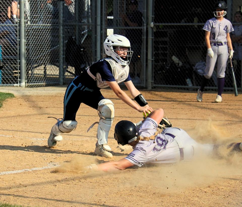 Lexington-Ridgeview's Mackenzie Wesson slides safely into home plate as Prairie Central catcher Lydia Kilgus makes the late tag in regional play at Seneca.