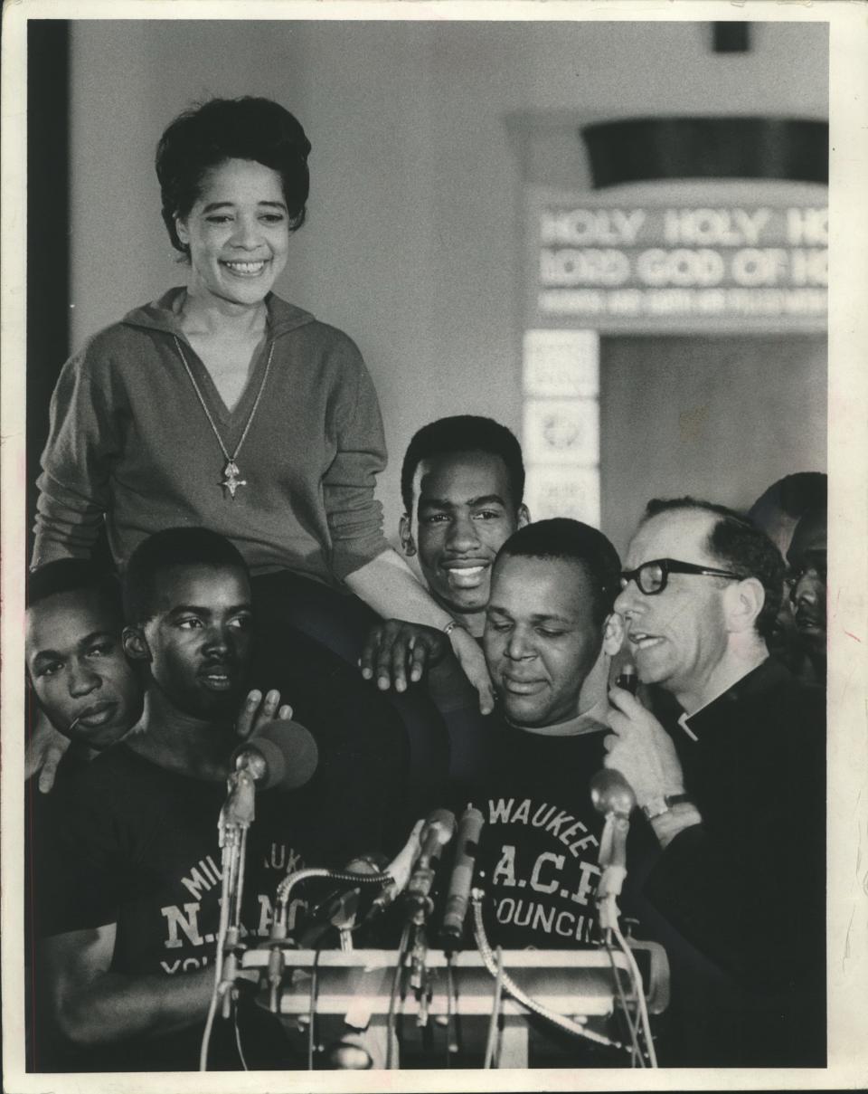Ald. Vel Phillips smiled as she was boosted to the shoulders of NAACP youth council commandos in 1967 while Father James Groppi spoke to the crowd at St. Boniface Catholic Church. Both later were arrested.