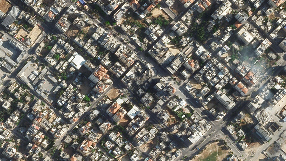 In this Sunday, May 16, 2021, satellite image provided by Planet Labs Inc. the rubble of a Gaza Strip high-rise building is seen in the center. An Israeli strike amid its fourth war with Gaza's Hamas rulers destroyed the al-Shorouk Tower. (Planet Labs Inc. via AP)