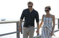 Britain's Prince Harry, left, and Meghan, Duchess of Sussex walk along Kingfisher Bay Jetty during a visit to Fraser Island, Australia, Monday, Oct. 22, 2018. Prince Harry and his wife Meghan are on day seven of their 16-day tour of Australia and the South Pacific. (AP Photo/Kirsty Wigglesworth, Pool)